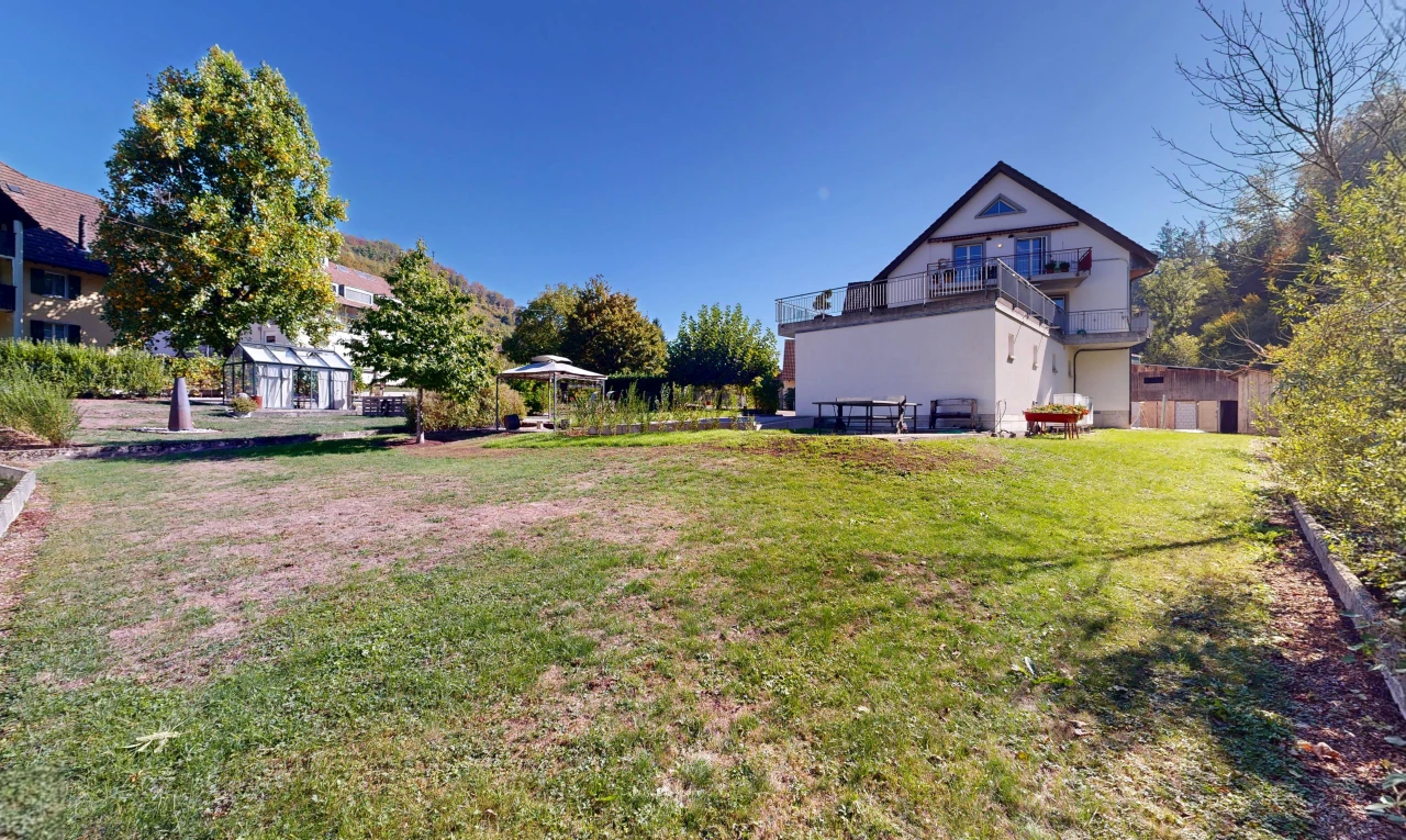 view of home with a lawn and a balcony