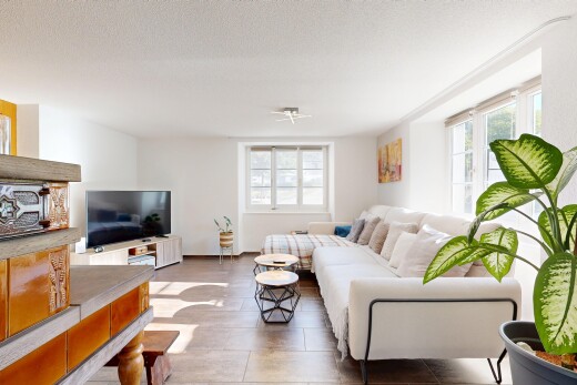 wohnzimmer mit natürliches licht, fernseher, drywall, gipskartonwand, und textured ceiling