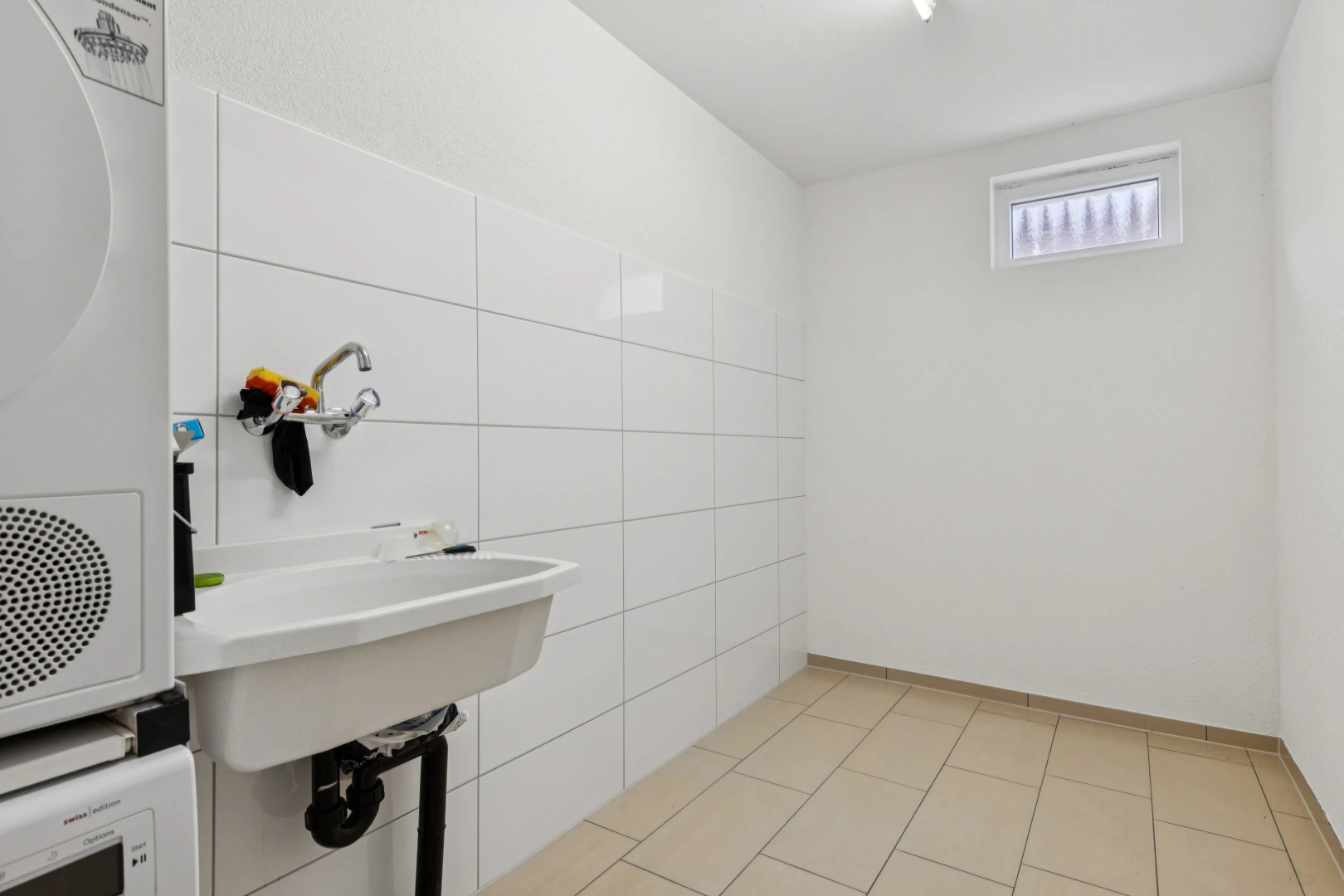 salle de bains avec tile wall, mur en carrelage, light floor, inside property, et drywall