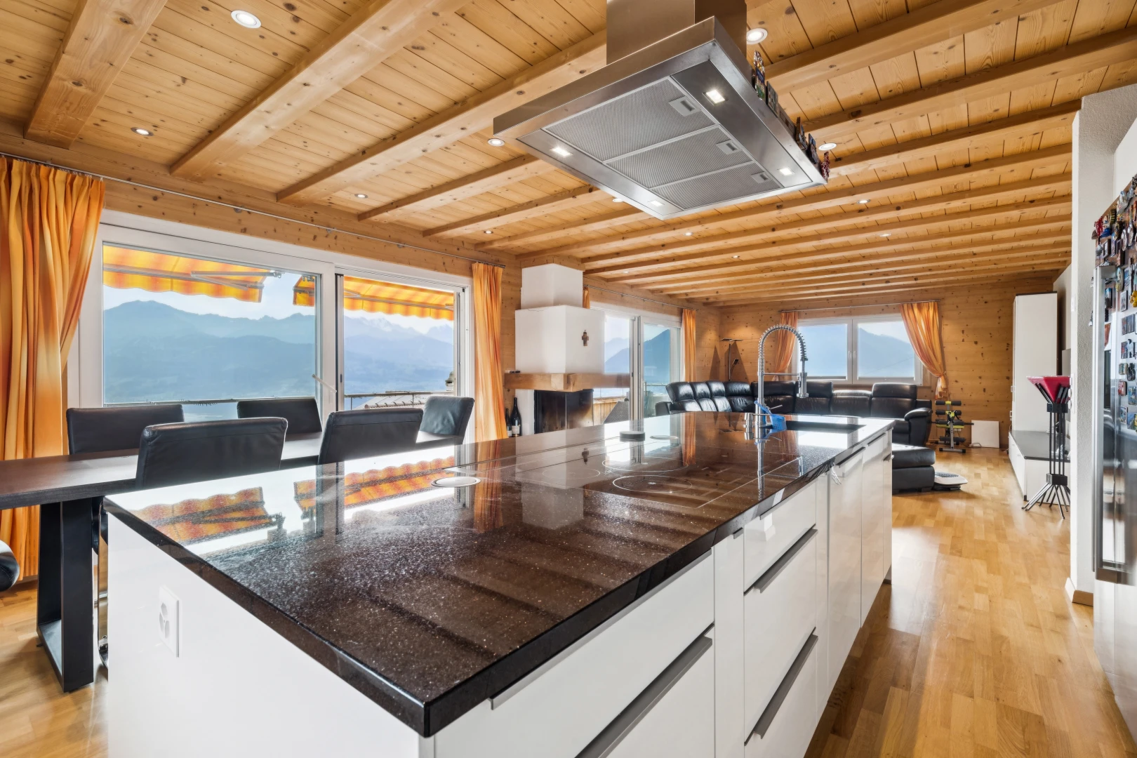 cuisine avec dark countertops, hotte, îlot de cuisine, kitchen island, et light floor