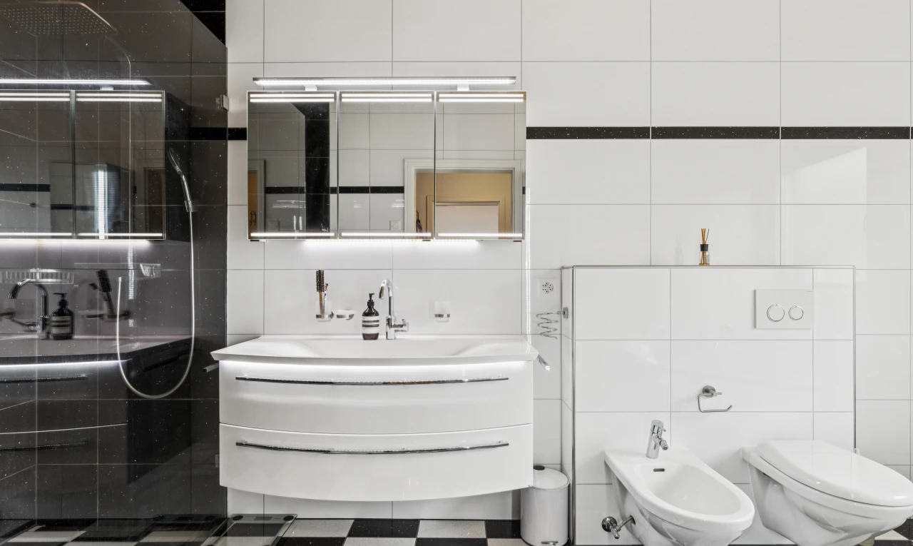 salle de bains avec bidet, lavabo (ou coiffeuse selon le contexte), salle de bain complète, mur en carrelage, et tile wall