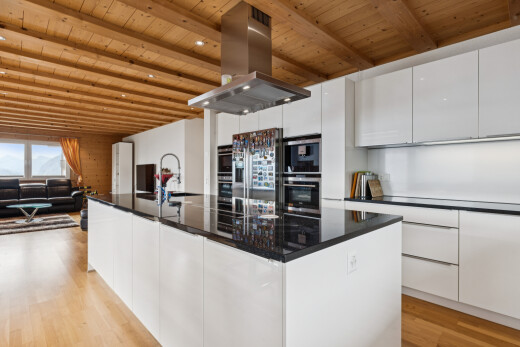 cuisine avec dark countertops, hotte, armoires à panneau plat, flat panel cabinets, et plafond en bois