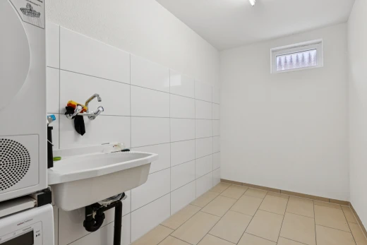 salle de bains avec tile wall, mur en carrelage, light floor, inside property, et drywall