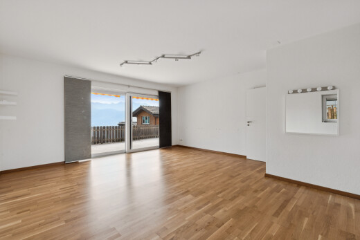 pièce vide avec drywall, cloison sèche, accès à l'extérieur, wood finish floor, et sol en finition bois