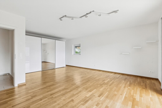 pièce vide avec cloison sèche, drywall, éclairage sur rail, sol en finition bois, et wood finish floor