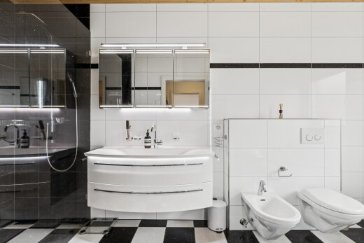 salle de bains avec bidet, lavabo (ou coiffeuse selon le contexte), salle de bain complète, mur en carrelage, et tile wall