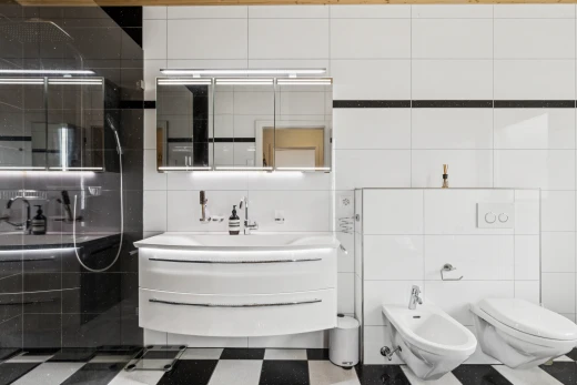 salle de bains avec bidet, lavabo (ou coiffeuse selon le contexte), salle de bain complète, mur en carrelage, et tile wall
