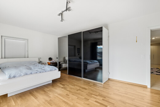 chambre avec drywall, cloison sèche, placard, wood finish floor, et sol en finition bois