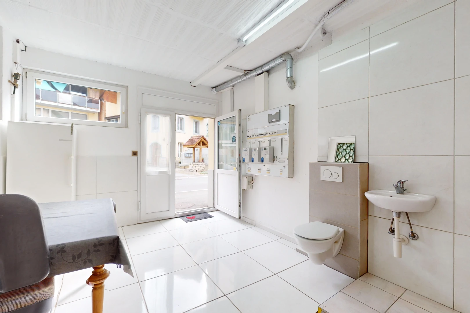 salle de bains avec lumière naturelle, toilettes, vasque, et carrelage