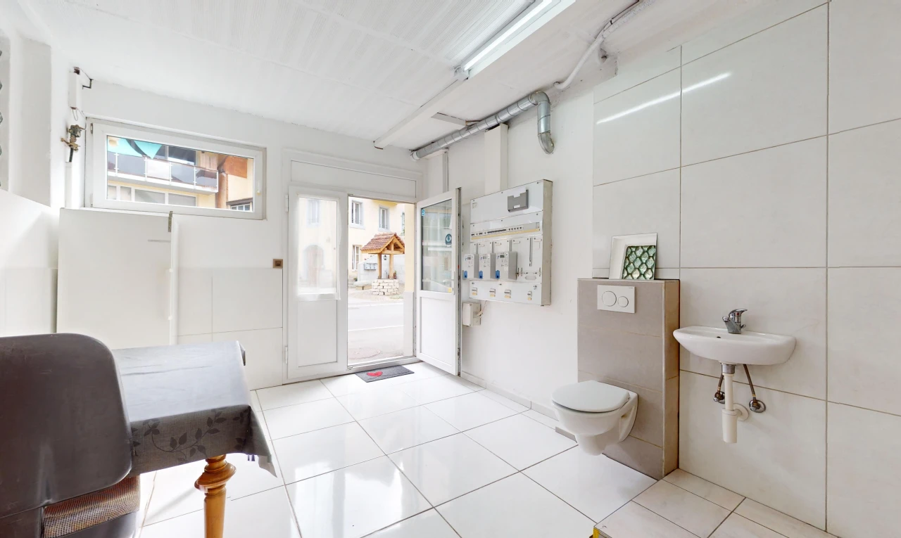salle de bains avec lumière naturelle, toilettes, vasque, et carrelage