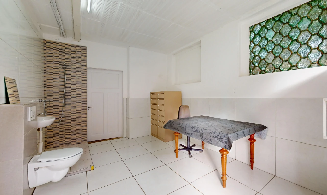 salle de bains avec mur carrelé, toilettes, et carrelage