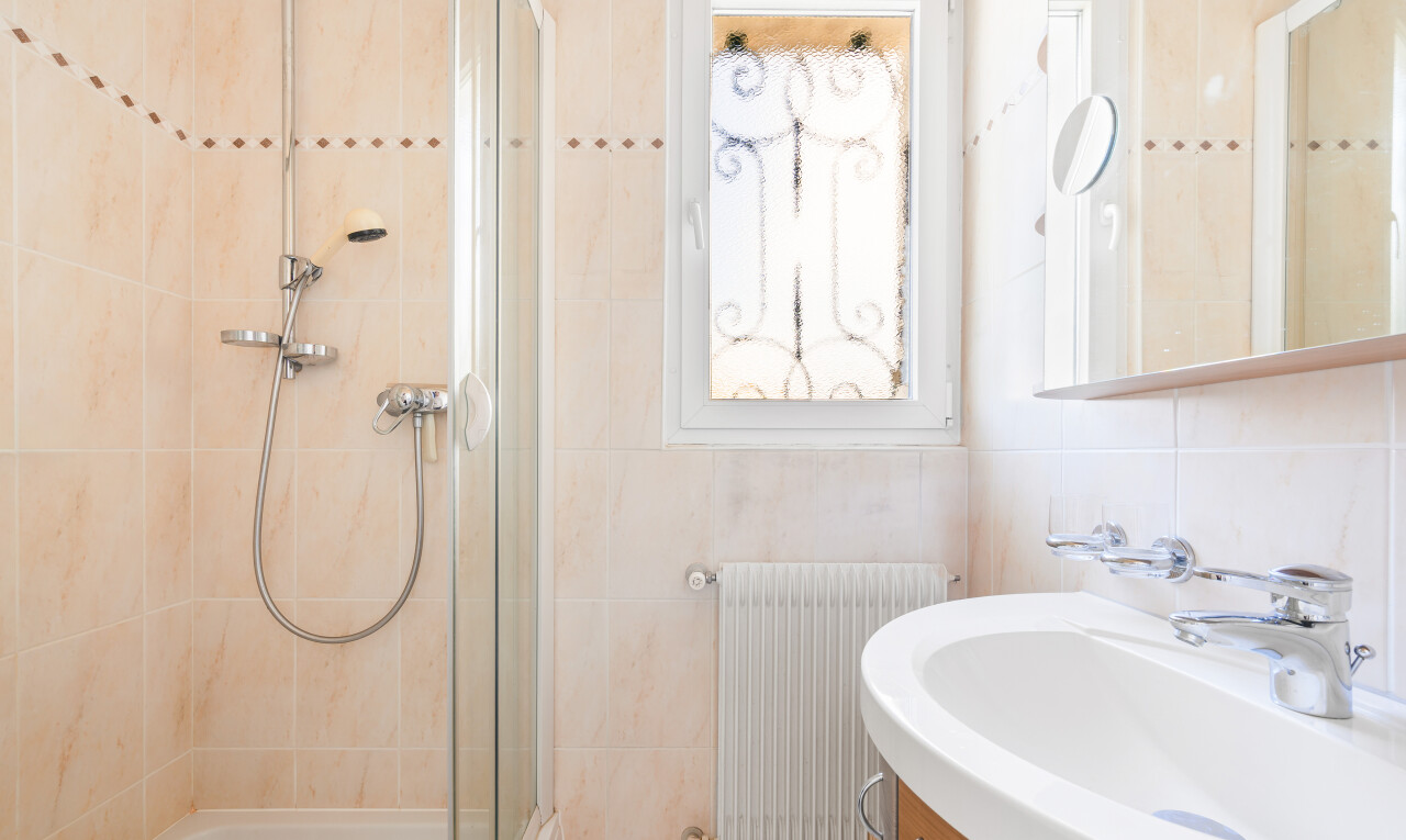 salle de bains avec miroir, évier, salle de bain complète, radiateur, et lavabo (ou coiffeuse selon le contexte)