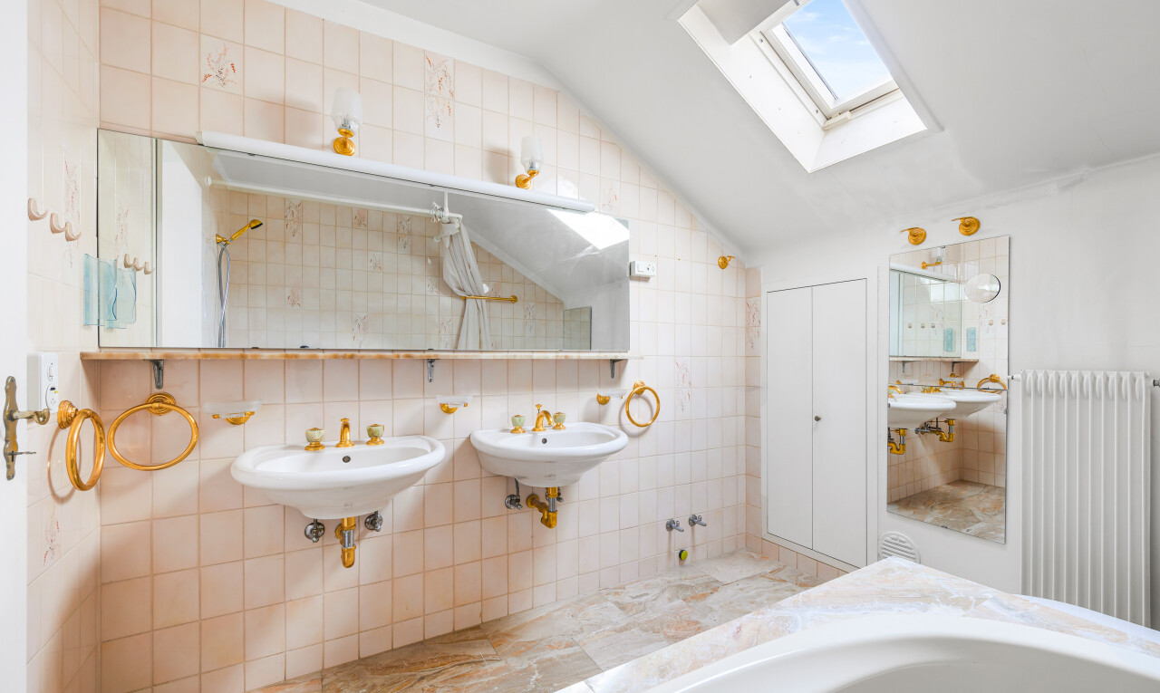 salle de bains avec tile wall, mur en carrelage, inside property, vaulted ceiling, et plafond voûté