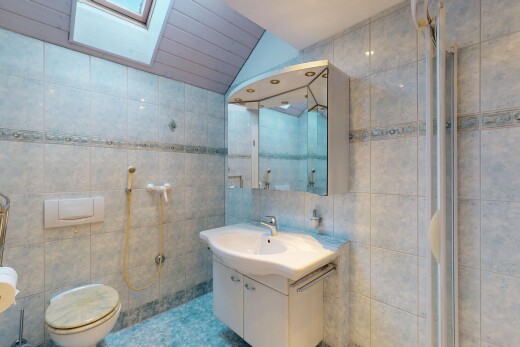 bad mit spiegel, dachfenster, dachschräge, fliesenwand, und toilette