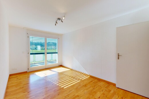 leerer raum mit deckenbeleuchtung, natürliches licht, holzfußboden, und gipskartonwand