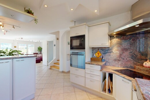 küche mit mikrowelle, fliesenboden, küchenrückwand beim herd, dunstabzugshaube, und ofen