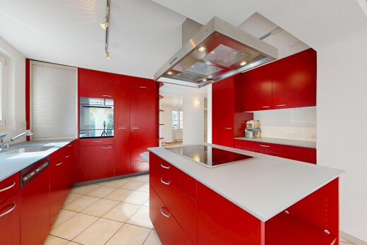 cuisine avec armoires rouges, red cabinets, hotte, îlot de cuisine, et kitchen island