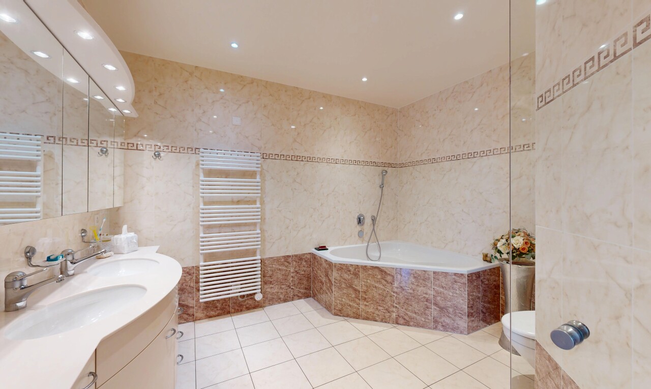 salle de bains avec chauffe-serviettes, mur en carrelage, tile wall, salle de bain complète, et inside property