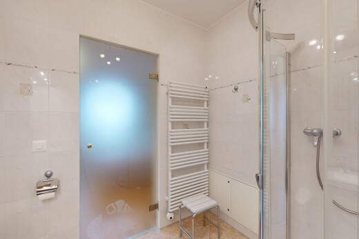 bathroom with radiator heating unit, a shower stall, and a towel warming rack