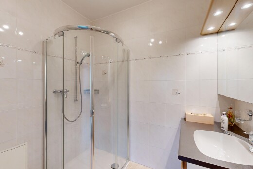 full bath with vanity, a shower stall, and tile walls