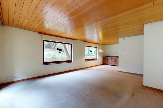 leerer raum mit gipskartonwand, teppich, natürliches licht, sockelleisten, und holzdecke