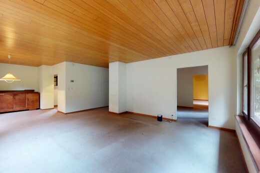 leerer raum mit gipskartonwand, betonboden, natürliches licht, sockelleisten, und holzdecke