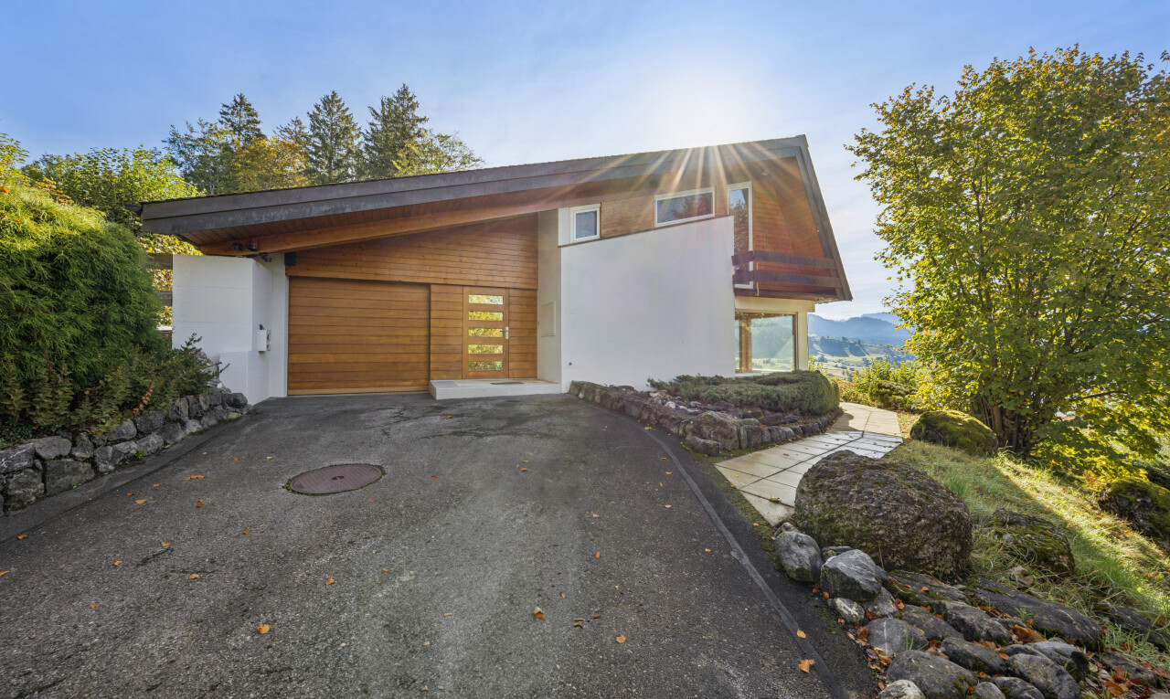 außenansicht mit auffahrt, holzverkleidung, horizontale verkleidung, property visible, und garage angeschlossen