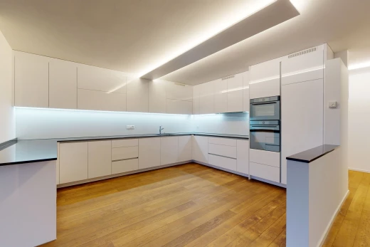 küche mit doppelofen, weissen schränken und hellen parkettböden