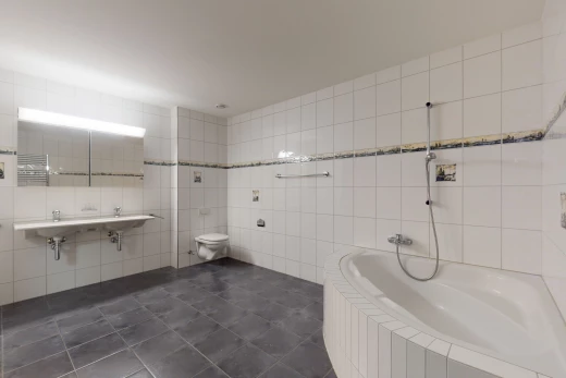 badezimmer mit fliesenböden, toiletten- und dusch- / waschbaumkombination