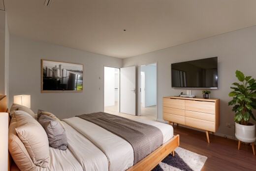 zimmer / schlafzimmer mit holzfußboden, gipskartonwand, und fernseher