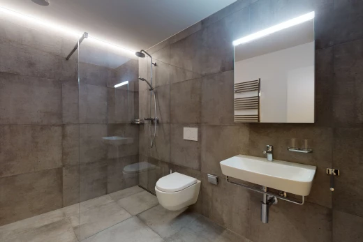 halbbad mit fliesenböden, spiegel, waschbecken und toilette