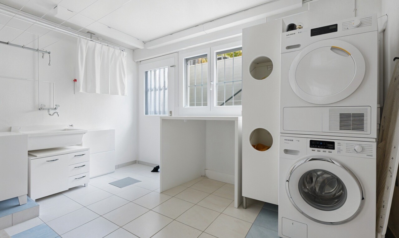 buanderie avec light floor, lave-linge et sèche-linge superposés, lumière naturelle, natural light, et inside property