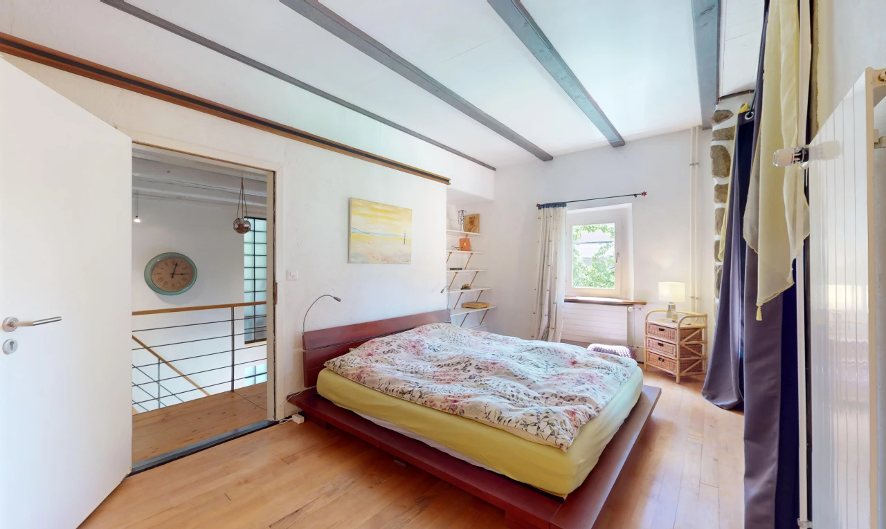 zimmer / schlafzimmer mit parkettboden, balkendecke, und natürliches licht