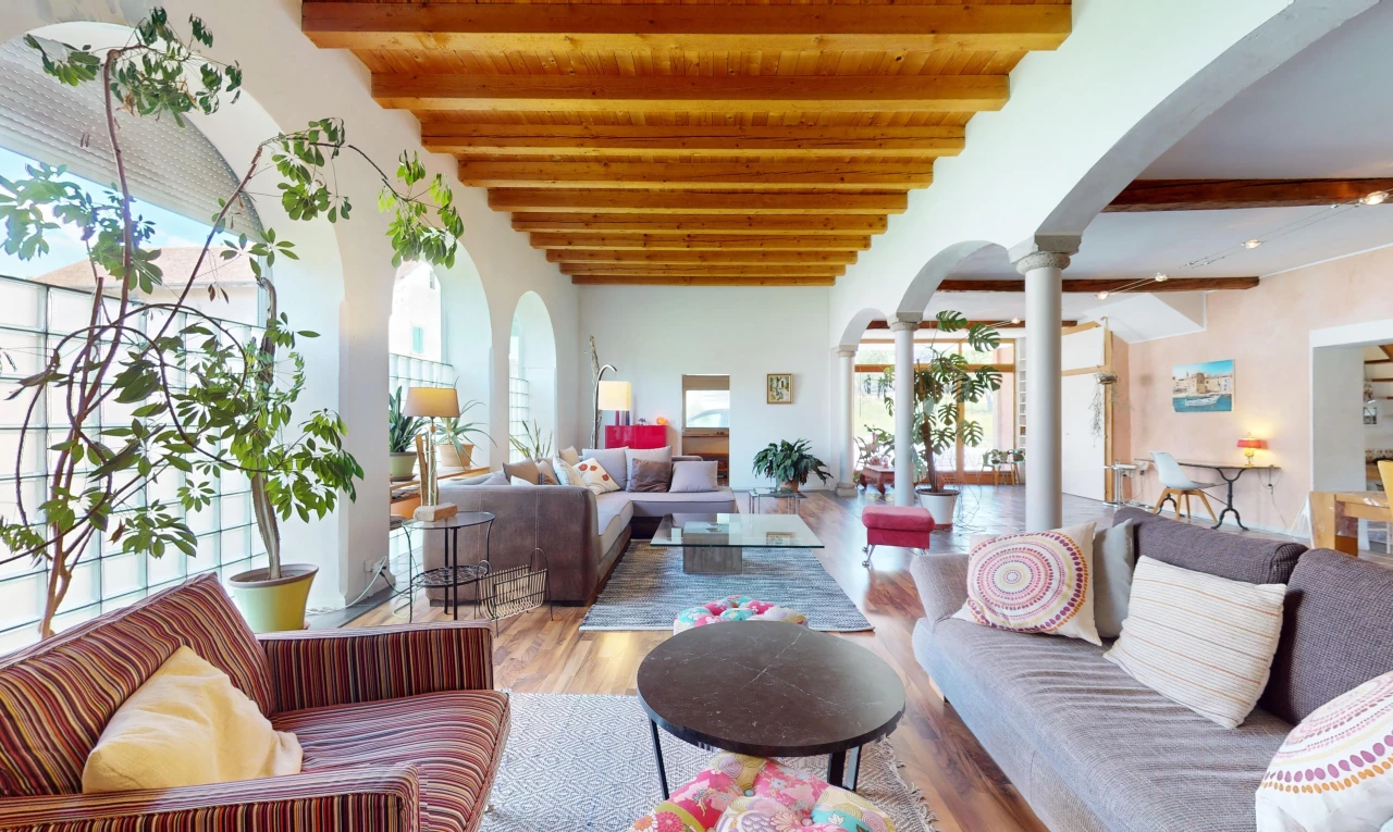 wohnzimmer mit dekorative säulen, balkendecke, gewölbte gehwege, parkettboden, und natürliches licht