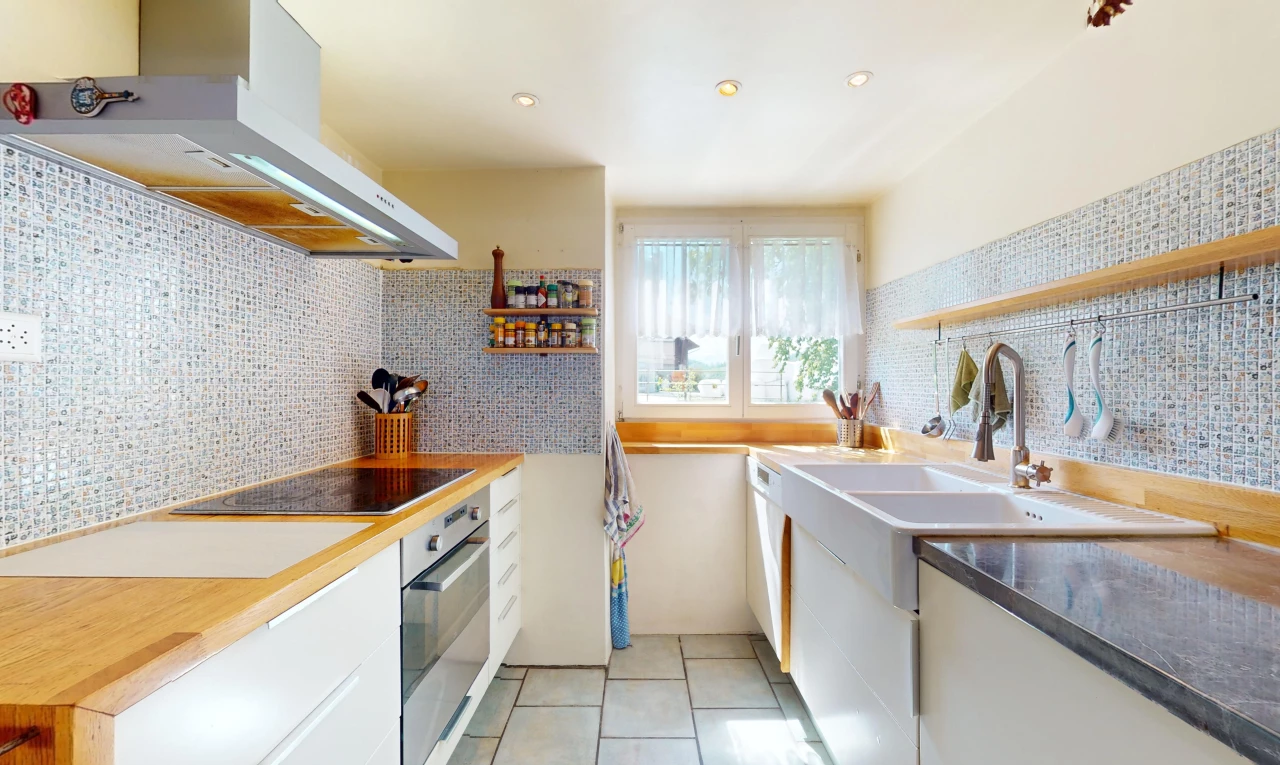 küche mit ofen, weiße schränke, backsplash, dunstabzugshaube, und natürliches licht