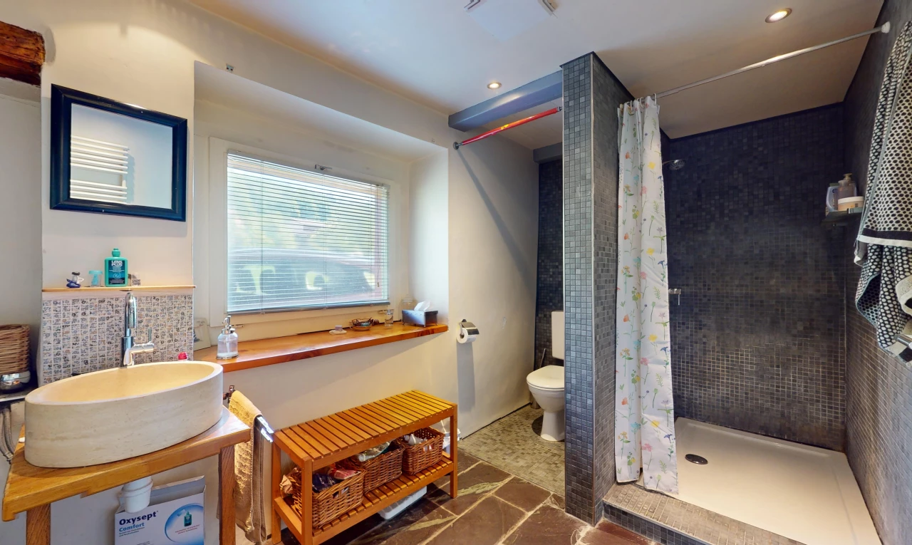 bad mit toilette, waschbecken, waschbeckenunterschrank, fliesenboden, und natürliches licht
