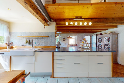 küche mit schränke mit flachen paneelen, weiße schränke, balkendecke, und natürliches licht