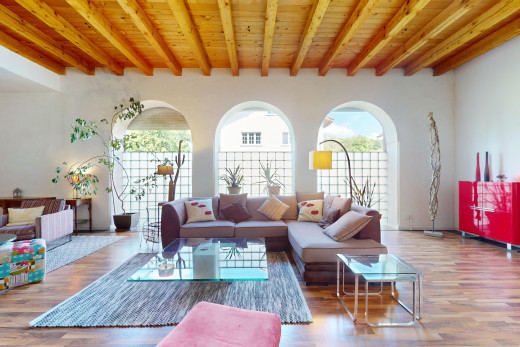 wohnzimmer mit parkettboden, holzdecke, balkendecke, und natürliches licht