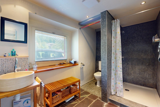 bad mit toilette, waschbecken, waschbeckenunterschrank, fliesenboden, und natürliches licht