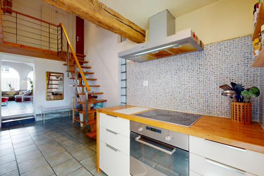 küche mit ofen, herd, weiße schränke, dunstabzugshaube, und natürliches licht