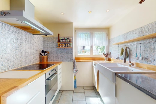 küche mit ofen, weiße schränke, backsplash, dunstabzugshaube, und natürliches licht