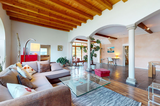 wohnzimmer mit balkendecke, dekorative säulen, natürliches licht, und gewölbte gehwege
