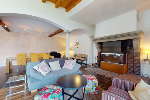 wohn- / esszimmer mit dekorative säulen, parkettboden, gewölbte gehwege, balkendecke, und kamin