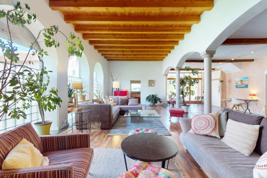 wohnzimmer mit dekorative säulen, balkendecke, gewölbte gehwege, parkettboden, und natürliches licht