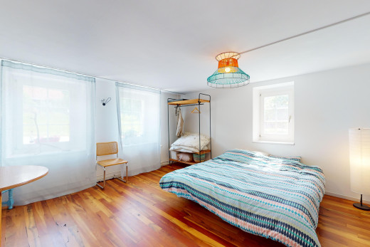 zimmer / schlafzimmer mit parkettboden und natürliches licht