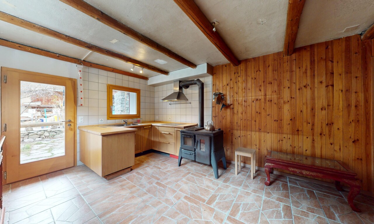 küche mit holzwand, holzofen, dunstabzugshaube, balkendecke, und natürliches licht