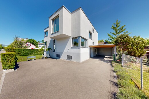 view of property with a carport, stucco siding, and a garage