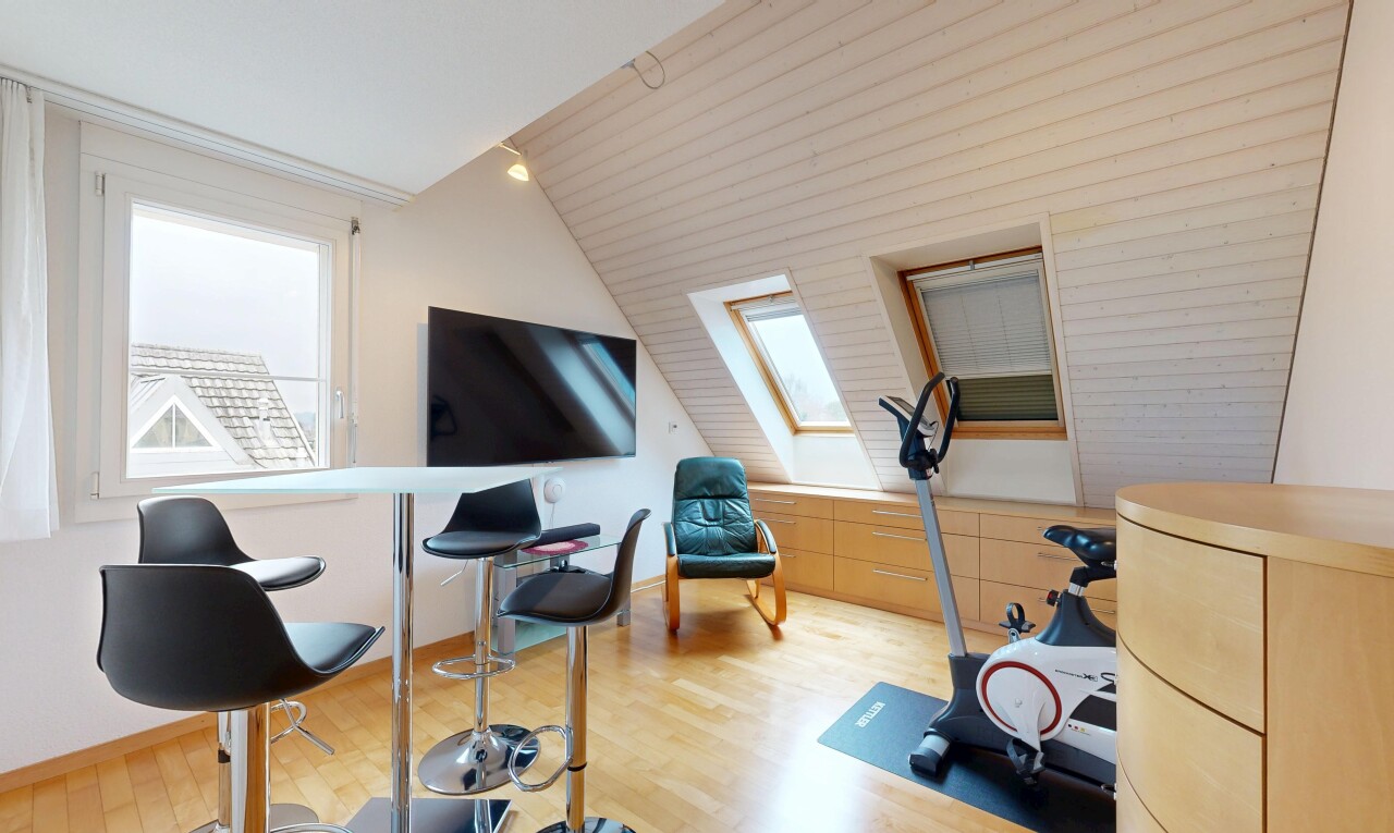 fitnessstudio mit fernseher, holzfußboden, wood finish floor, dachschräge, und vaulted ceiling