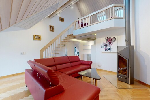 living room featuring rail lighting, a towering ceiling, and stairs