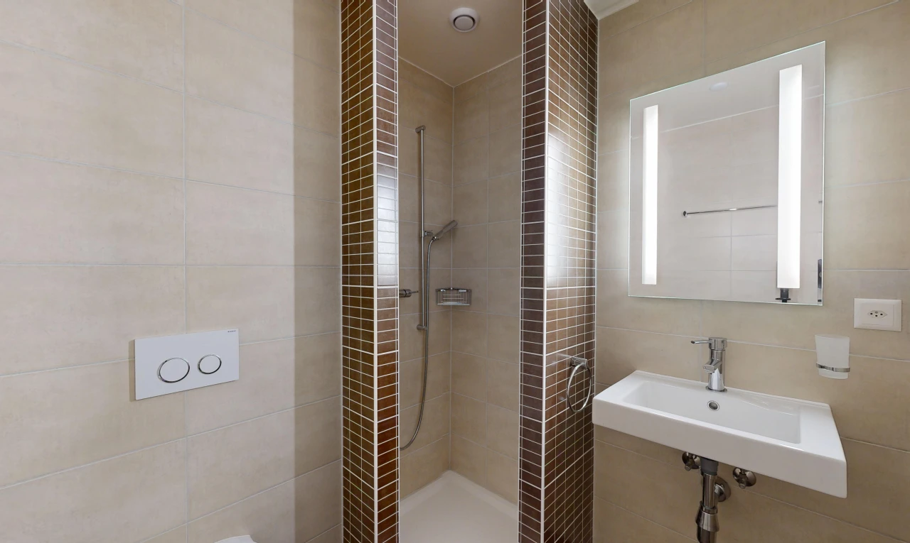 salle de bains avec douche, miroir, salle de bain complète, évier, et tile wall